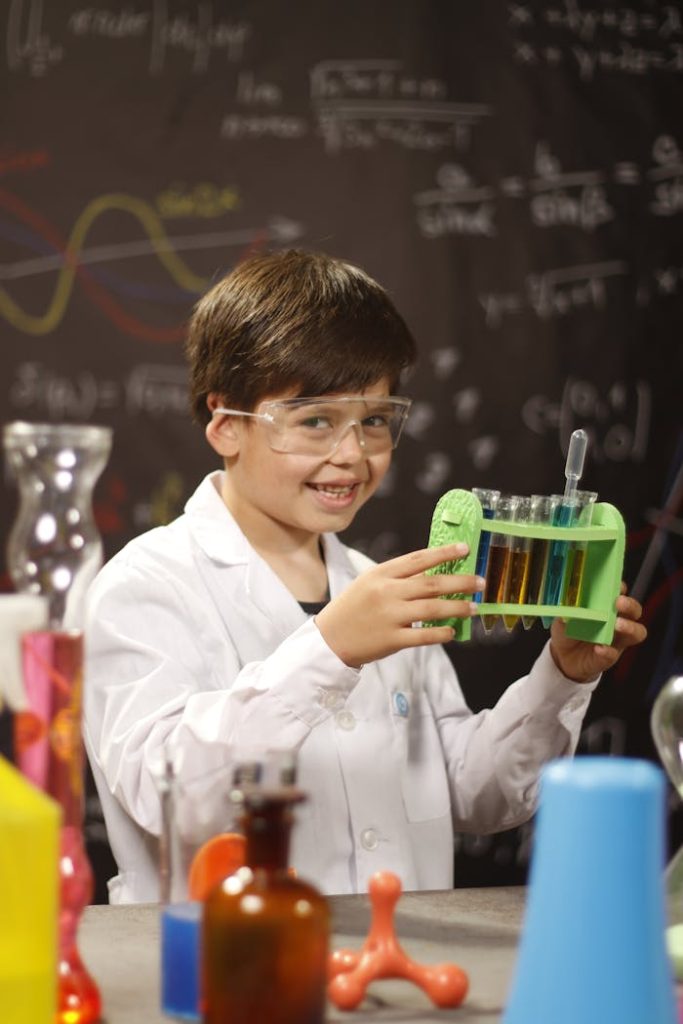 Smiling child performing a science experiment with test tubes in a classroom lab setting.